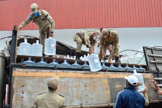 Bombeiros Militares descarregando galões de 20 litros de álcool 