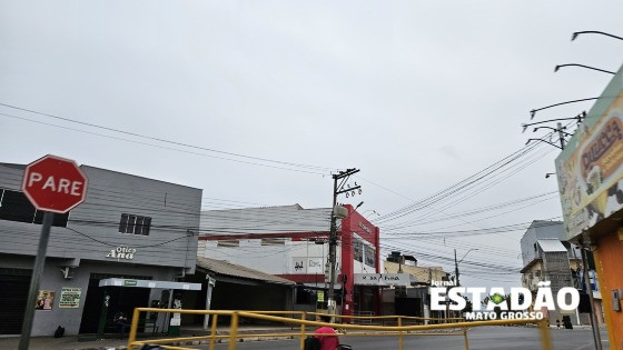 Cuiabano se encolhe no guarda-chuva em meio à ventania desta quarta (28); previsão indica mais frio e pancadas nos próximos dias