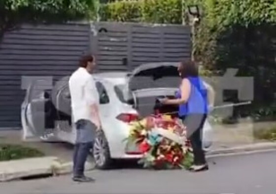 Mulher coloca coroa de flores na casa de Lula